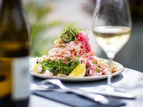 King Size shrimp sandwich with hand-peeled shrimp, dill and lemon, served on a plate.