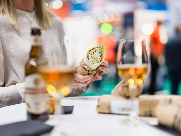 Meal with a wrap and drinks in an exhibition setting.